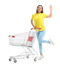 Photo of Young woman with empty shopping cart on white background