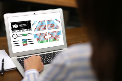 Image of Woman buying theater tickets online via laptop at table, closeup