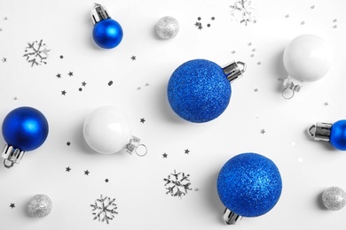 Photo of Colorful Christmas balls and sparkles on white background, top view