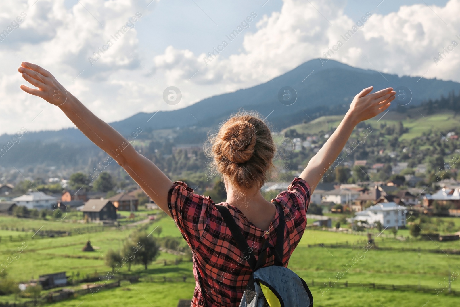 Photo of Young woman enjoying beautiful view of village in mountains