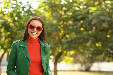 Photo of Beautiful woman wearing red sunglasses in green park