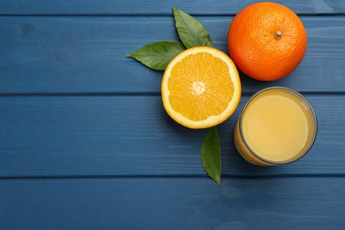 Photo of Delicious orange juice and fresh fruit on blue wooden table, flat lay. Space for text