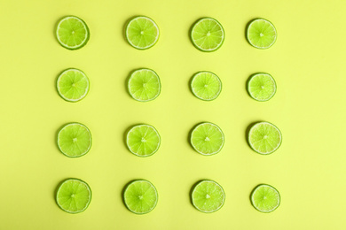 Photo of Flat lay composition with fresh juicy limes on yellow background