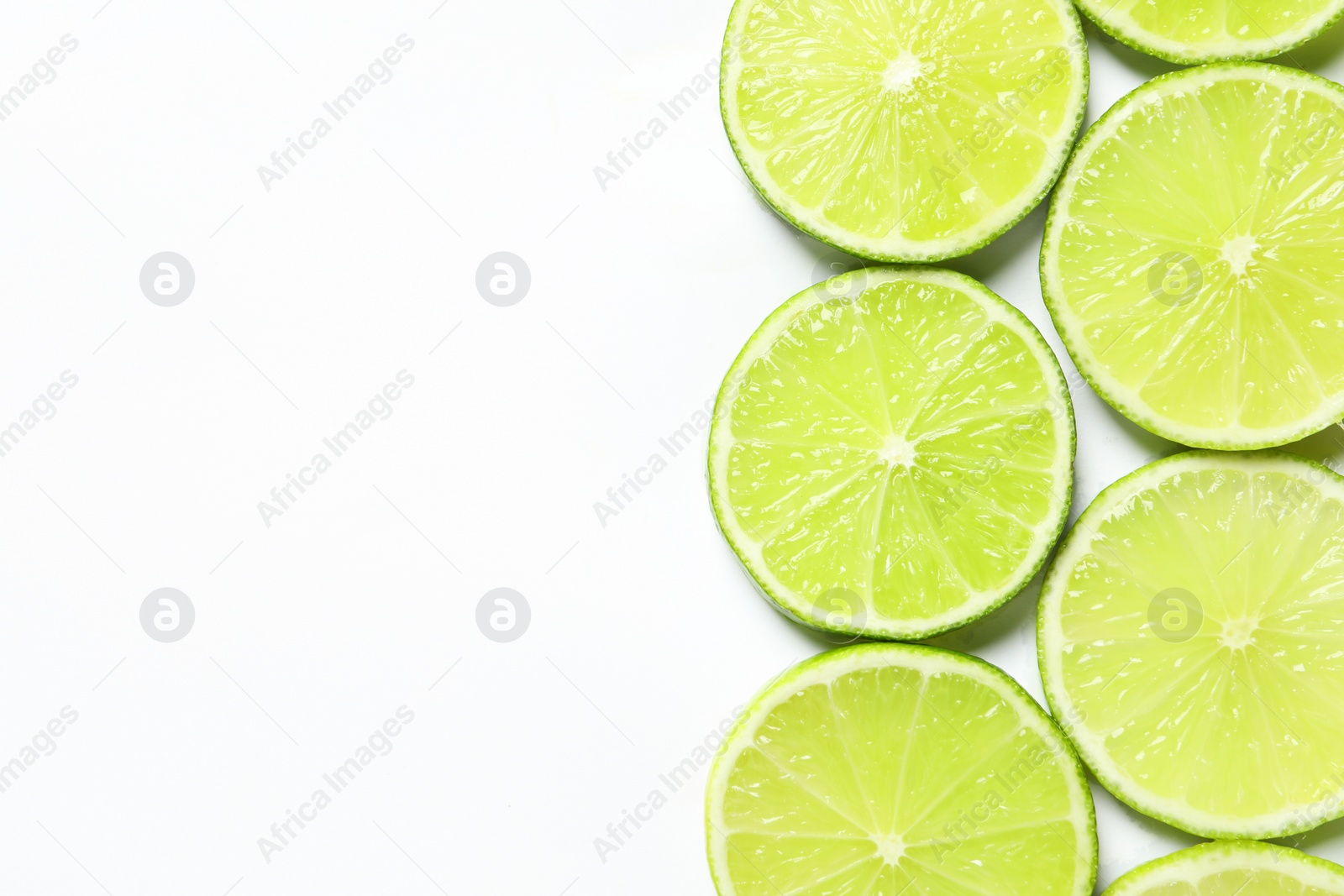 Photo of Fresh juicy lime slices on white background, flat lay. Space for text