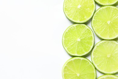 Photo of Fresh juicy lime slices on white background, flat lay. Space for text