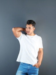 Photo of Young man in t-shirt on grey background. Mockup for design
