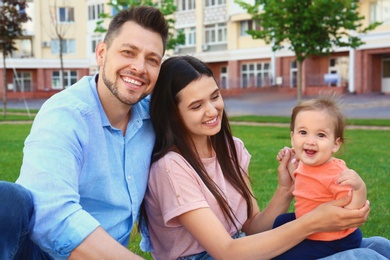 Photo of Happy family with adorable little baby outdoors