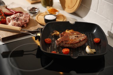 Photo of Frying pan with fresh raw meat and vegetables on stove
