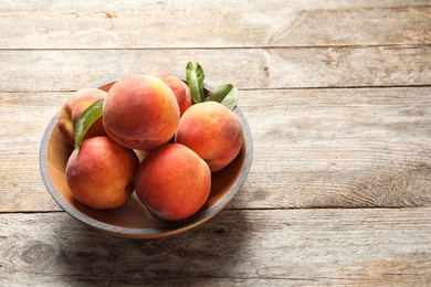 Photo of Plate with fresh sweet peaches on wooden table