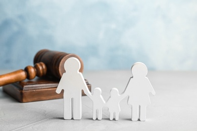 Photo of Family figure and gavel on table. Family law concept