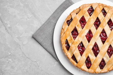 Photo of Delicious fresh cherry pie on light grey table, top view. Space for text