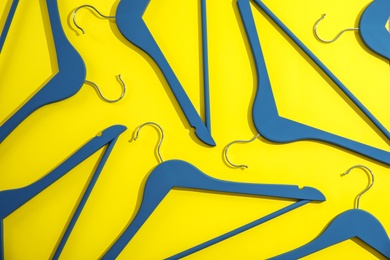 Photo of Flat lay composition with empty hangers on color background