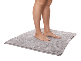 Photo of Woman standing on soft grey bath mat against white background, closeup