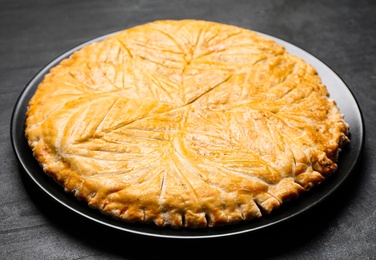 Photo of Traditional galette des rois on black table, closeup