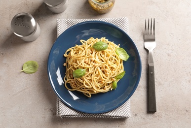 Photo of Plate of delicious basil pesto pasta served for dinner on table, flat lay