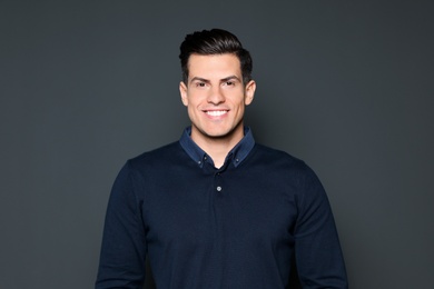 Photo of Portrait of handsome man smiling on grey background