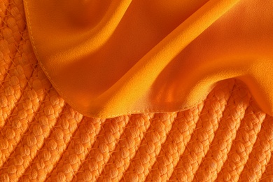 Photo of Orange fabric on wicker mat, top view
