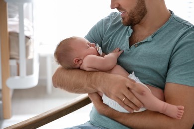 Photo of Father with his newborn son at home, closeup