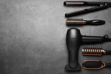 Photo of Flat lay composition of professional hairdresser tools on dark grey table, space for text