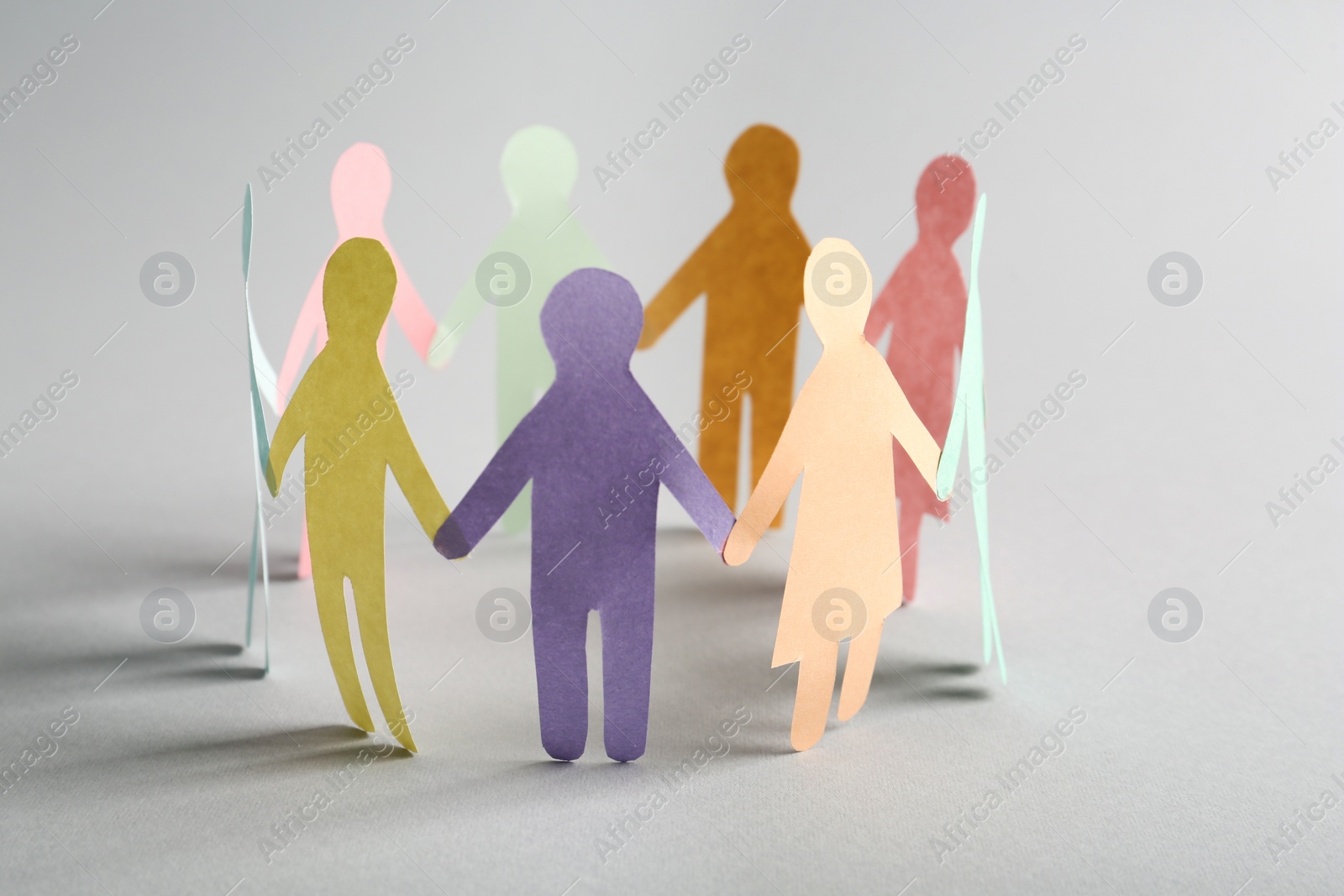 Photo of Paper human figures making circle on white background. Diversity and Inclusion concept