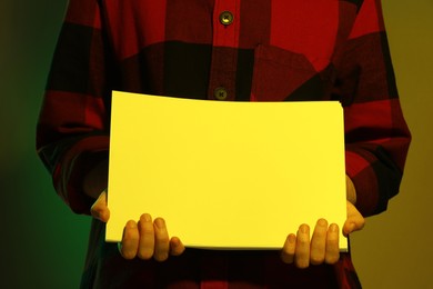 Man holding sheets of paper on dark background, closeup and space for text. Color tone effect