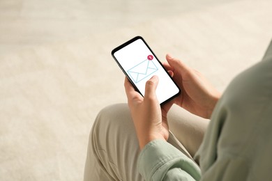 Image of Woman checking new message on mobile phone indoors, closeup
