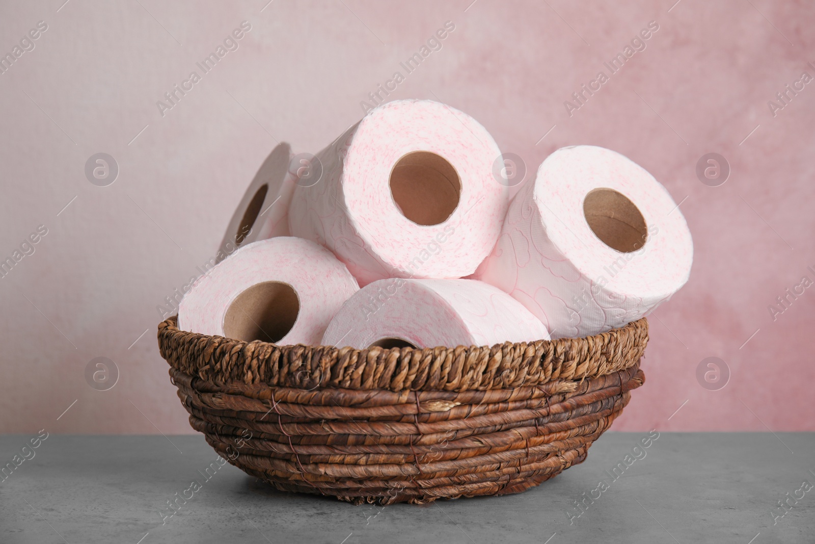 Photo of Wicker bowl with toilet paper rolls on table