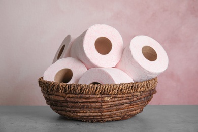 Photo of Wicker bowl with toilet paper rolls on table
