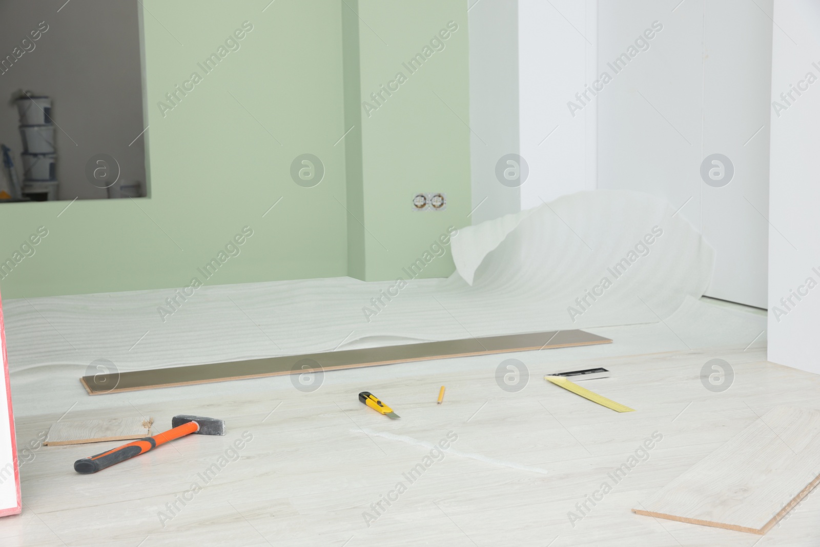 Photo of Light room with unfinished laminate flooring and different tools