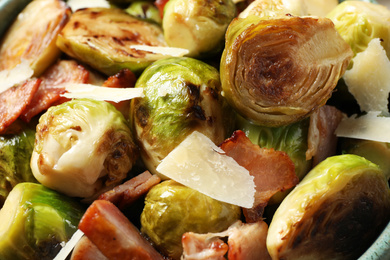 Delicious fried Brussels sprouts with bacon as background, closeup