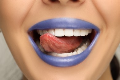 Photo of Woman with blue lipstick showing her tongue, closeup