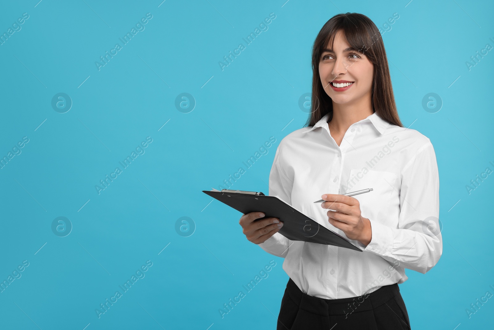 Photo of Happy secretary with clipboard and pen on light blue background. Space for text