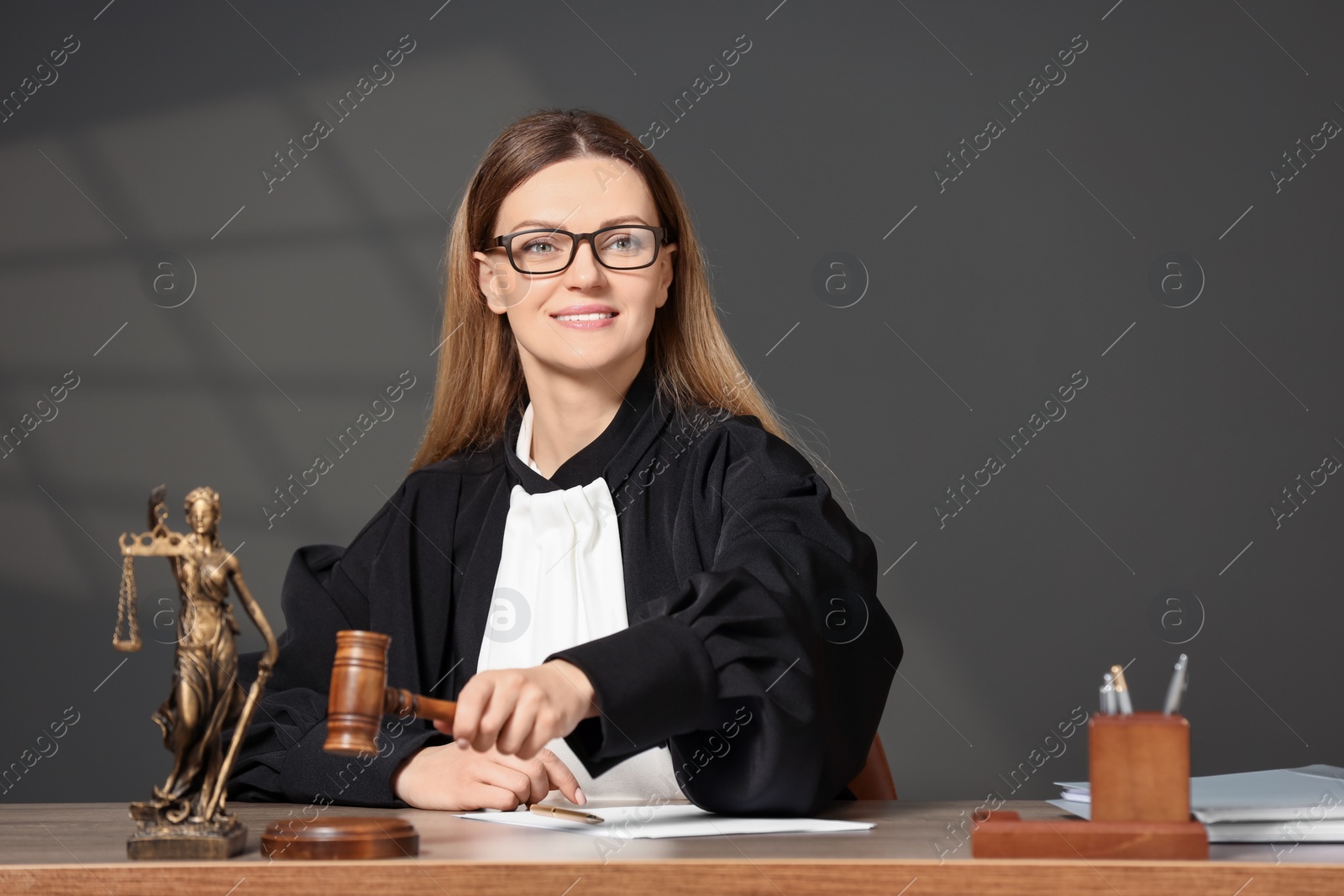 Photo of Judge striking mallet at wooden table indoors