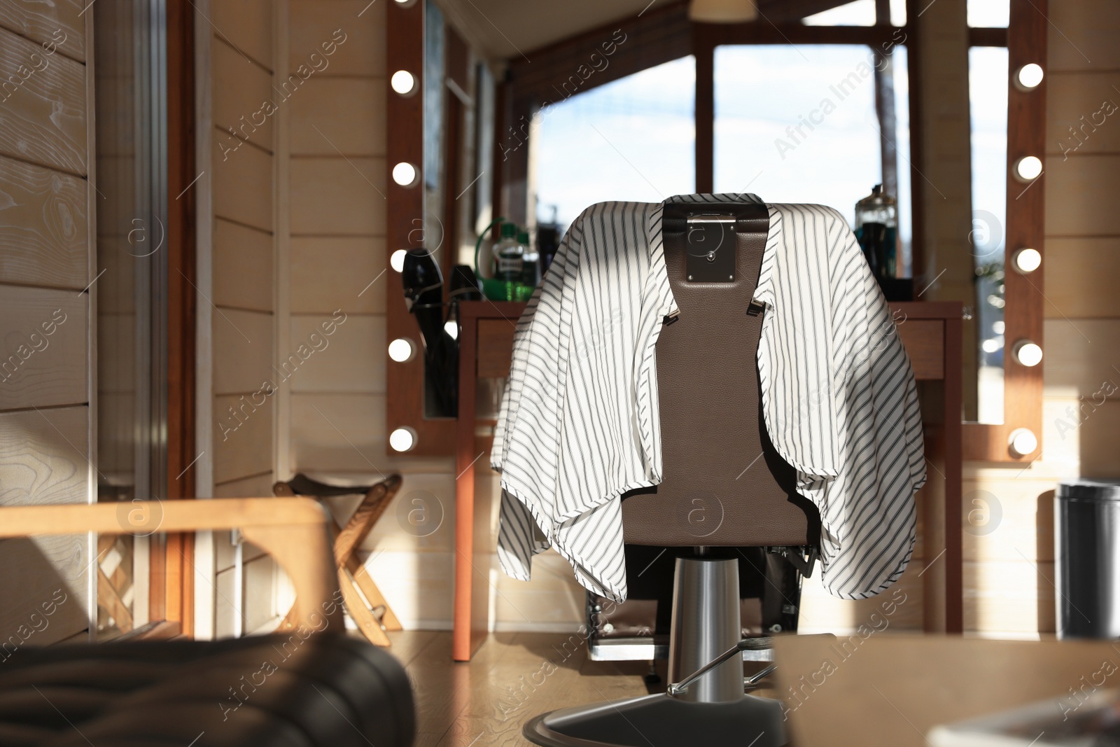 Photo of Stylish hairdresser's workplace with professional armchair in barbershop