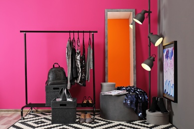 Photo of Stylish dressing room interior with clothes rack and mirror