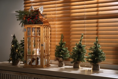 Beautiful Christmas lantern on windowsill in decorated room
