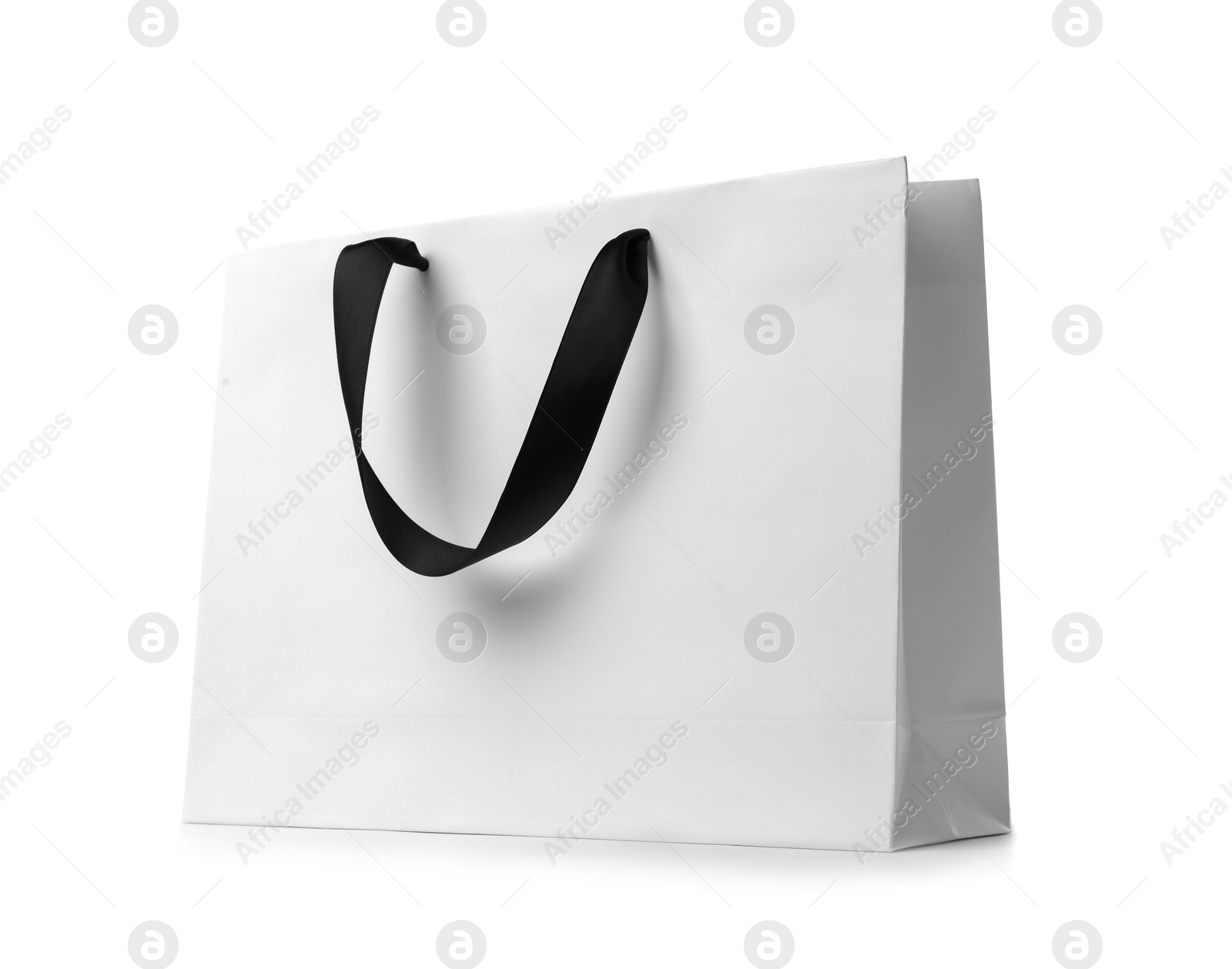 Photo of Paper shopping bag with ribbon handles on white background. Mockup for design