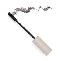 Photo of Applicator brush and brown mascara stroke on white background, top view