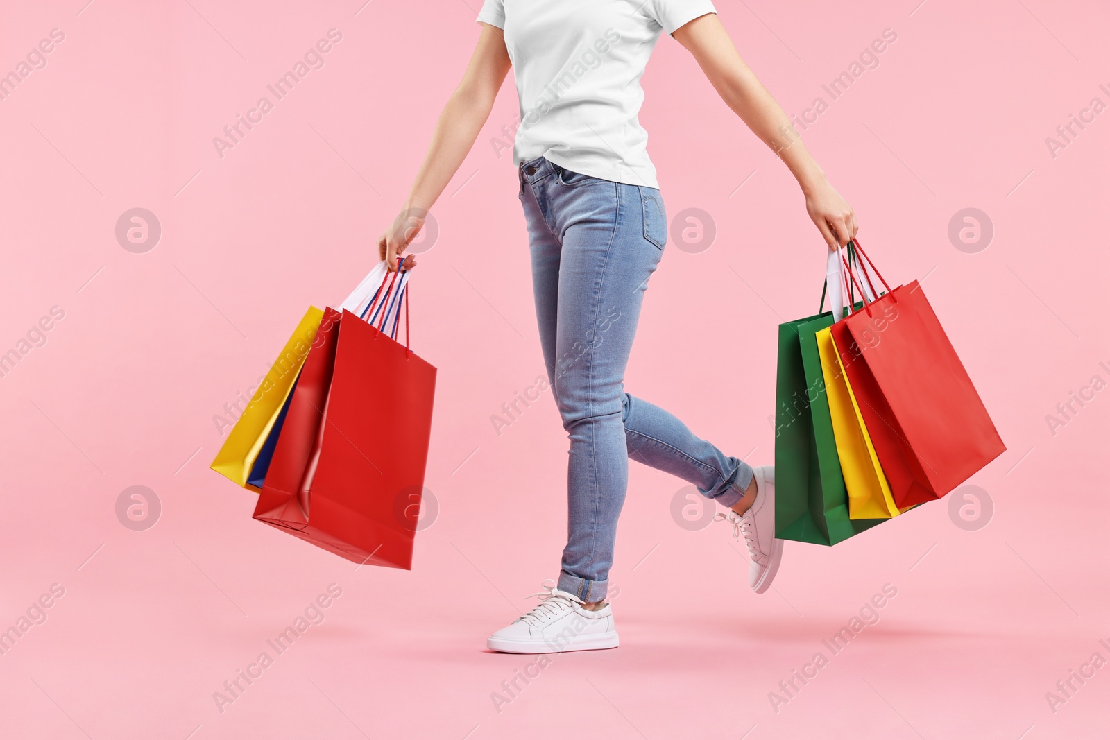 Photo of Woman with shopping bags on pink background, closeup