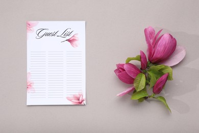 Photo of Guest list and beautiful flowers on grey background, flat lay. Space for text