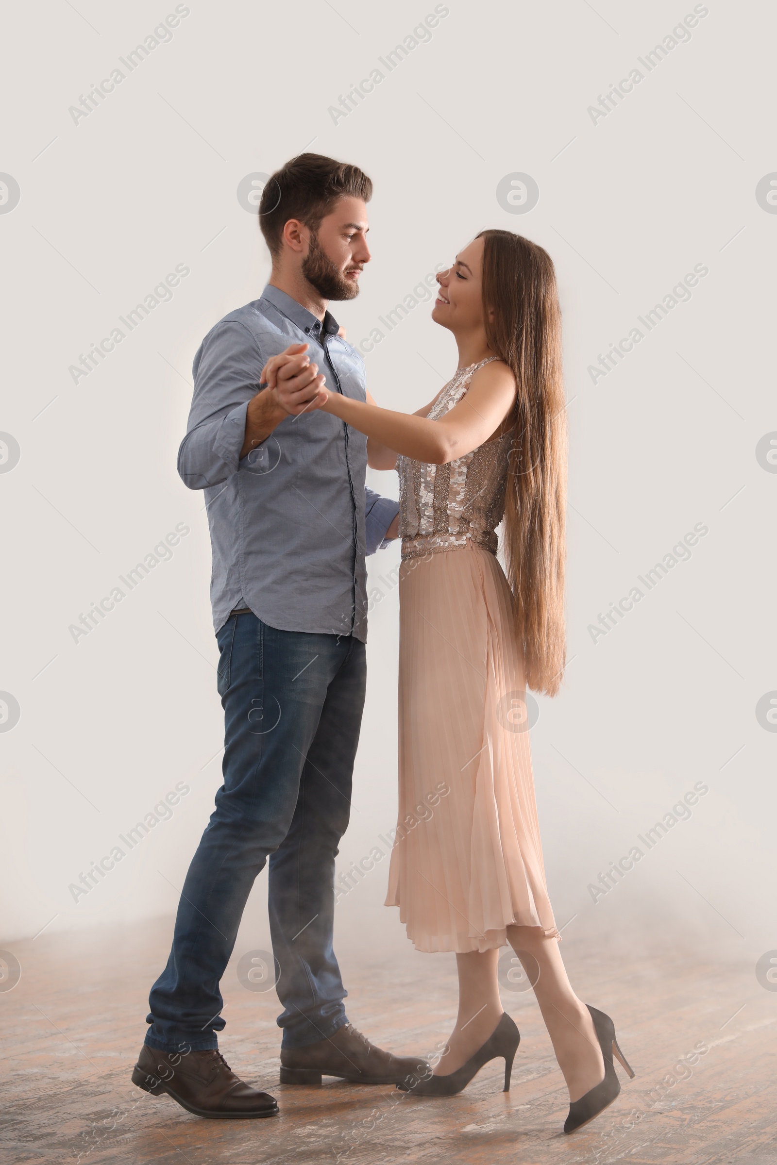 Photo of Lovely young couple dancing together in ballroom