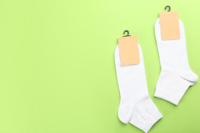 Photo of Soft cotton socks on light green background, flat lay. Space for text