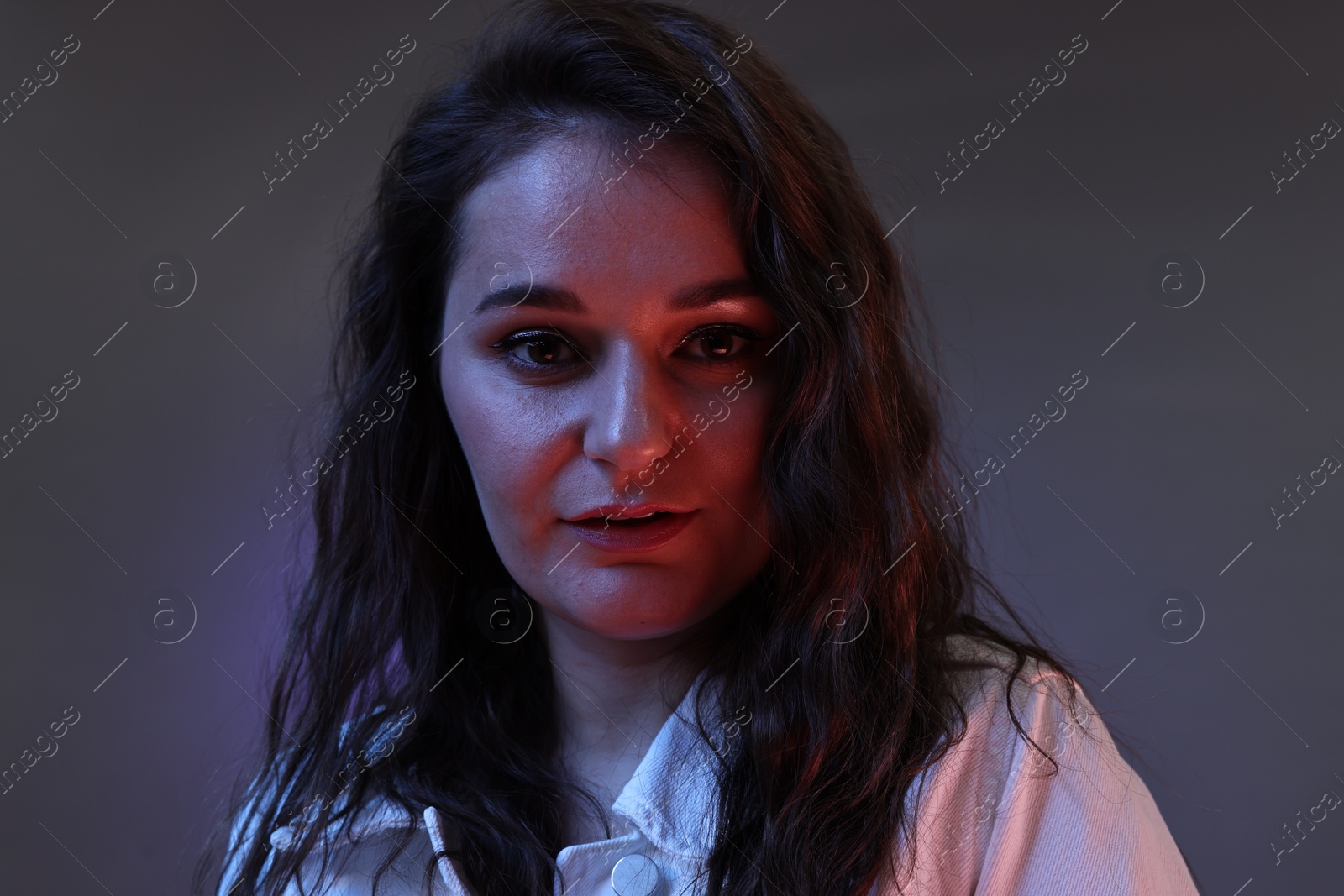 Photo of Portrait of beautiful young woman on color background with neon lights