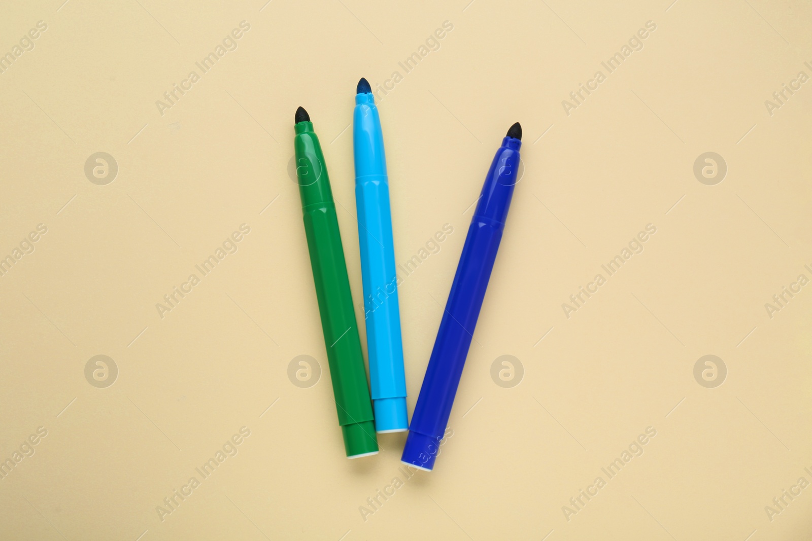 Photo of Different colorful markers on beige background, flat lay