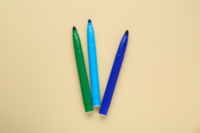Photo of Different colorful markers on beige background, flat lay