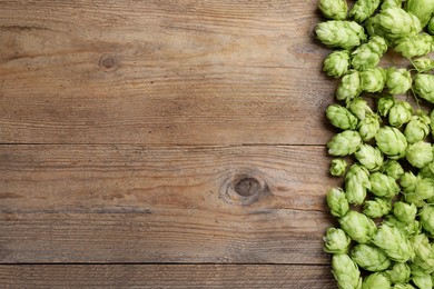 Fresh green hops on wooden table, top view. Space for text