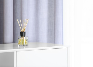 Photo of Aromatic reed air freshener on chest of drawers at home