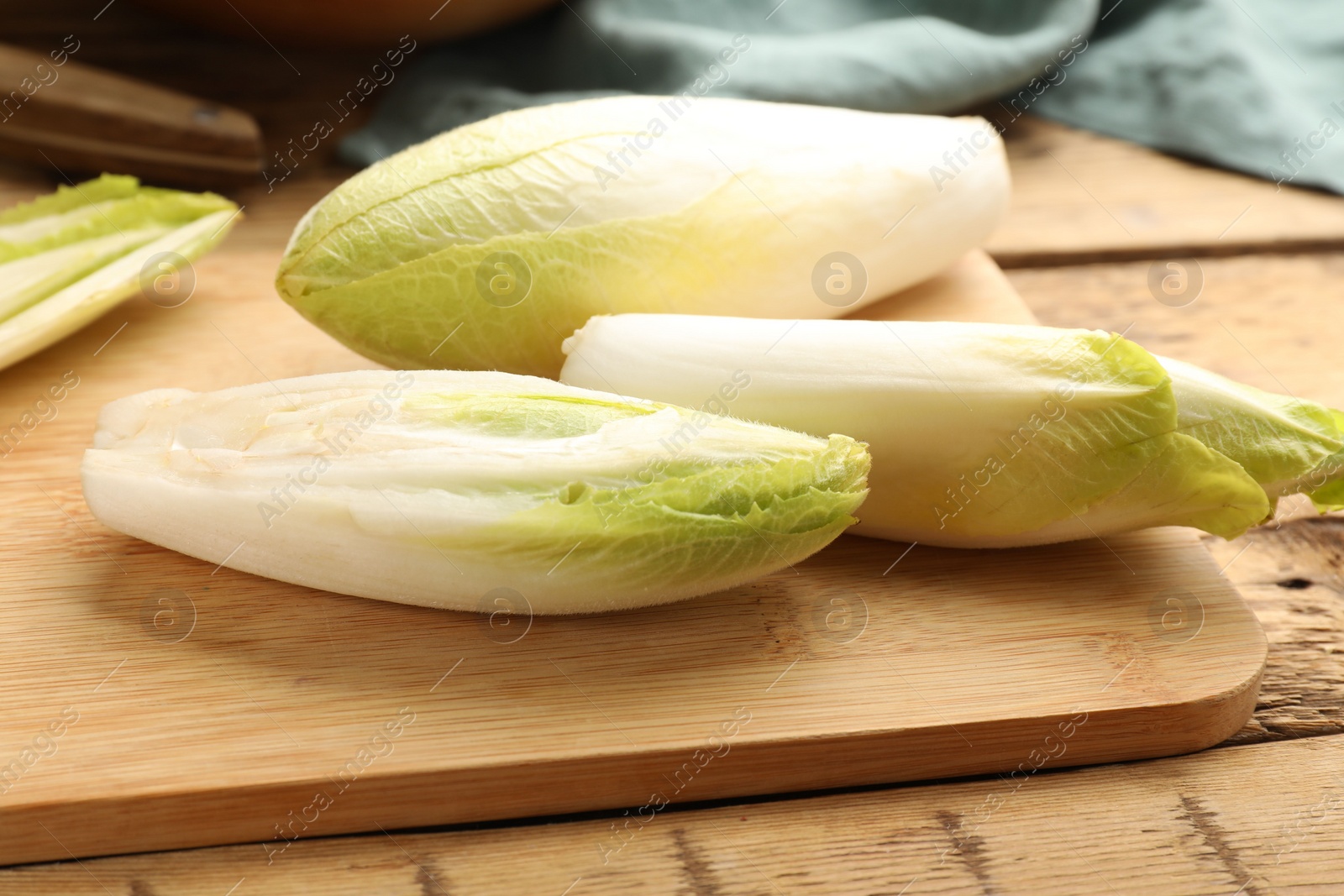 Photo of Fresh raw Belgian endives (chicory) on wooden table, closeup