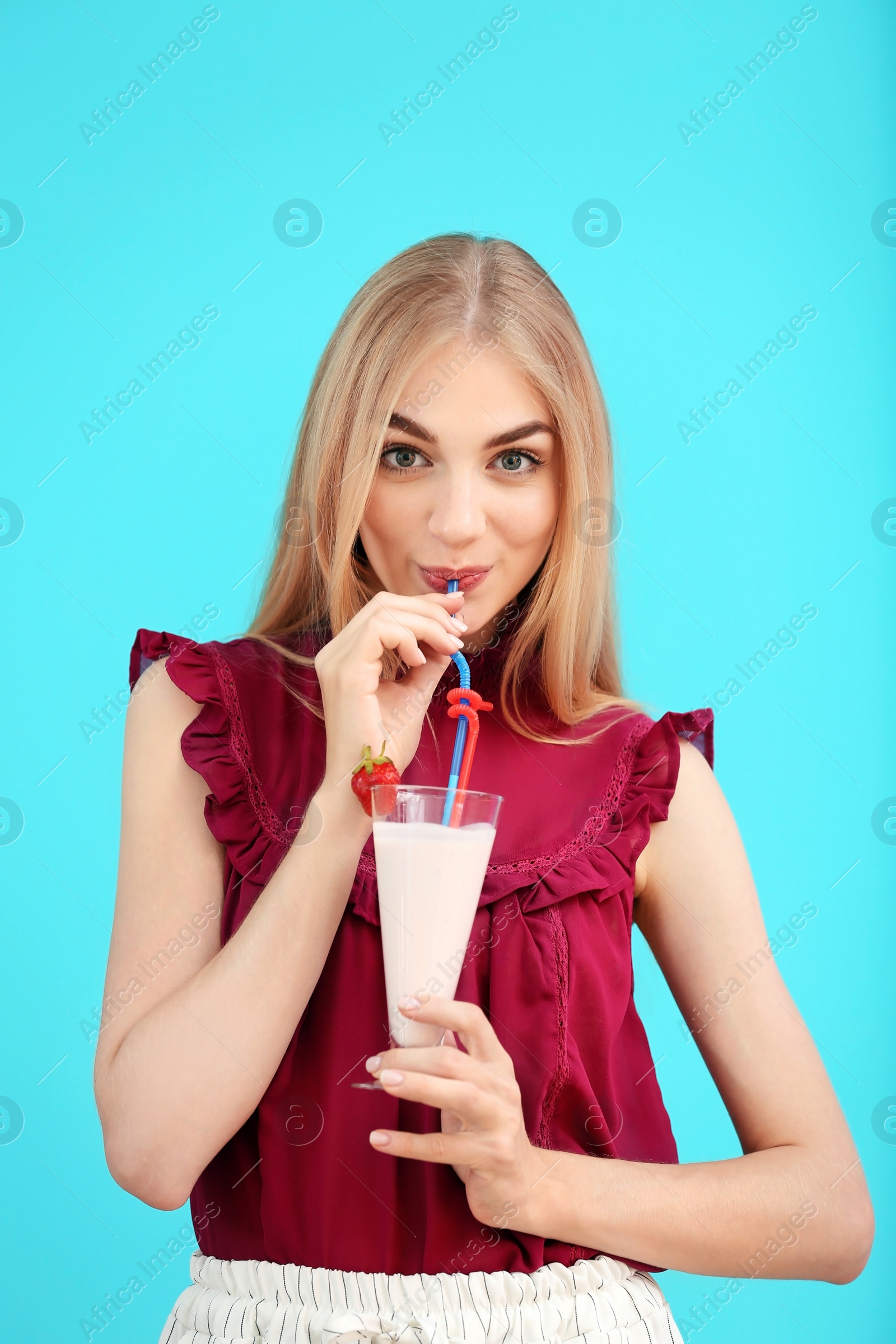 Photo of Young woman with glass of delicious milk shake on color background