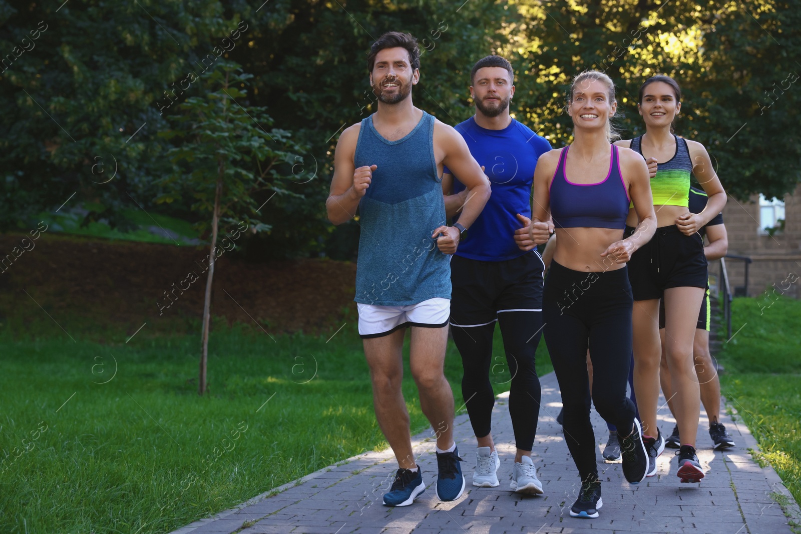 Photo of Group of people running in park. Space for text